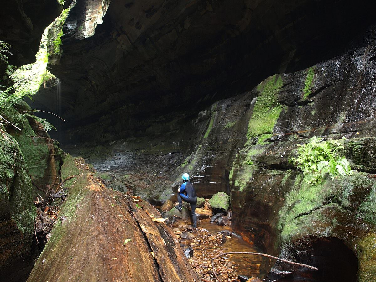 A canyoner descending through a narrow slot canyon near Blackheath